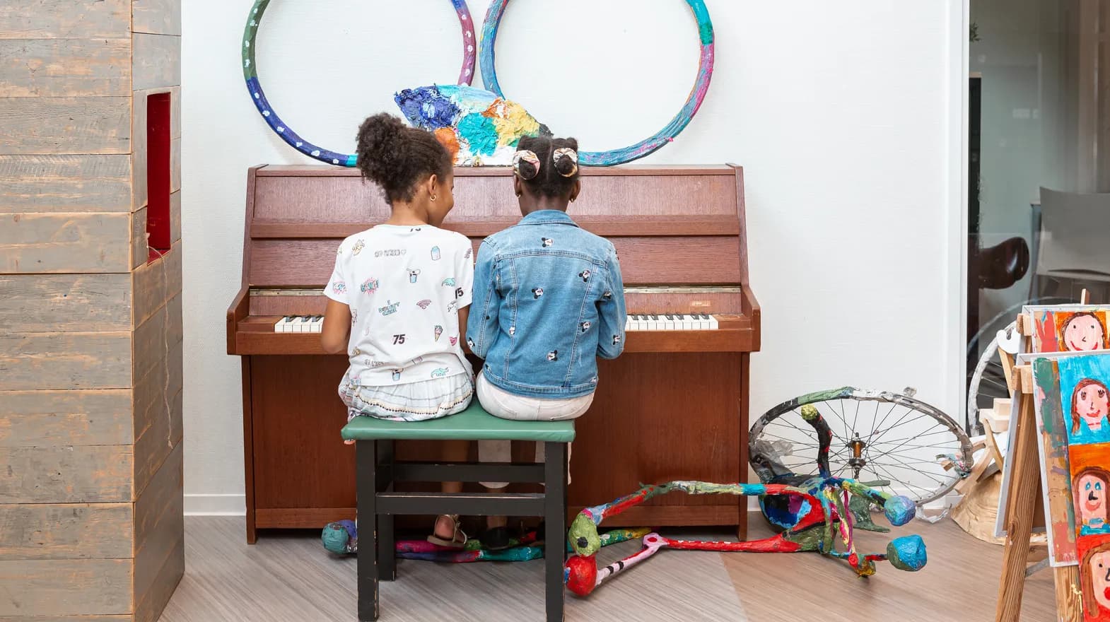 Kinderen spelen samen op de piano bij de BSO van kinderopvang Kind&co ludens