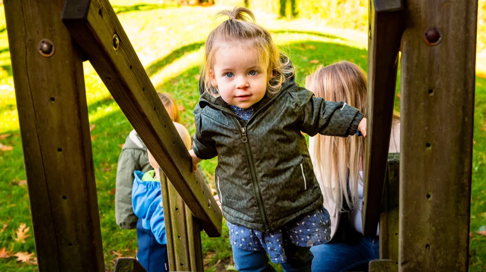 Kind speelt buiten op een speeltoestel bij kinderopvang Kind&co ludens