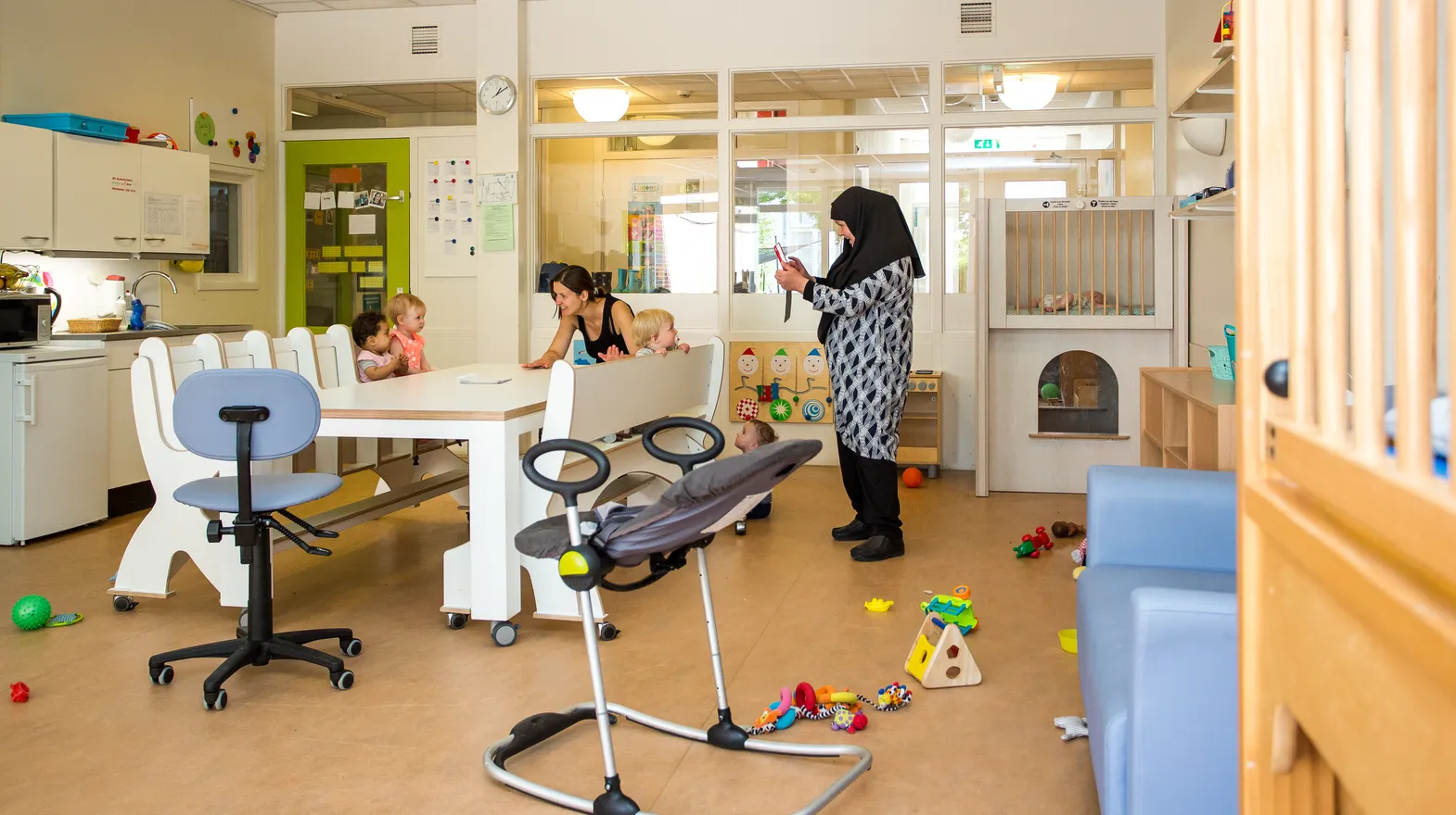 Pedagogisch medewerker maakt foto via de groeps-tablet van kinderen voor de ouders thuis bij kinderdagverblijf Jodokus, kinderopvang Kind&co ludens