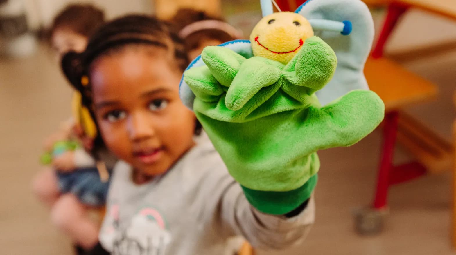 Kind van de peutergroep speelt met handpop bij kinderopvang Kind&co ludens