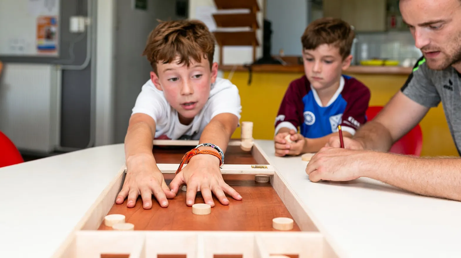 Kinderen aan het sjoelen bij BSO Sprint Baarn van kinderopvang Kind&co ludens