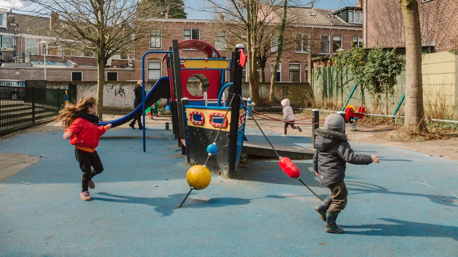 Kinderen spelen buiten met een speeltoestel bij kinderopvang Kind&co ludens