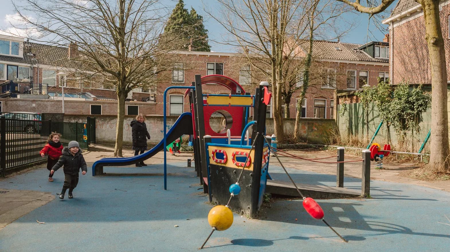 Kinderen spelen buiten bij de klimboot bij peuteropvang Warmoes, kinderopvang Kind&co ludens