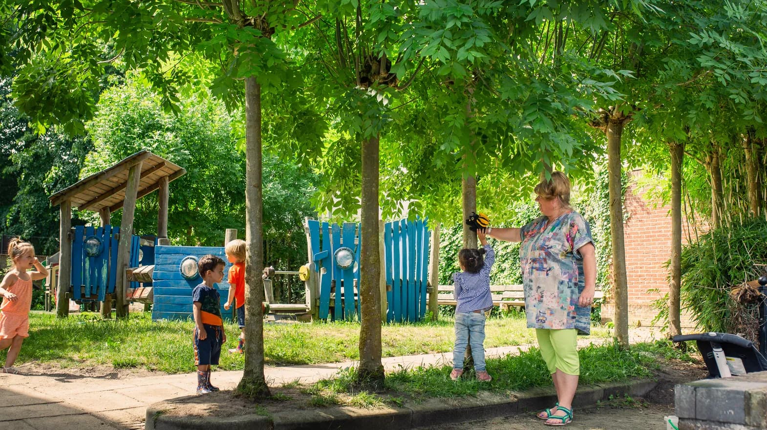 Kinderen spelen in de tuin met een bijen handpop bij peuteropvang 't Egeltje, Kind&co ludens