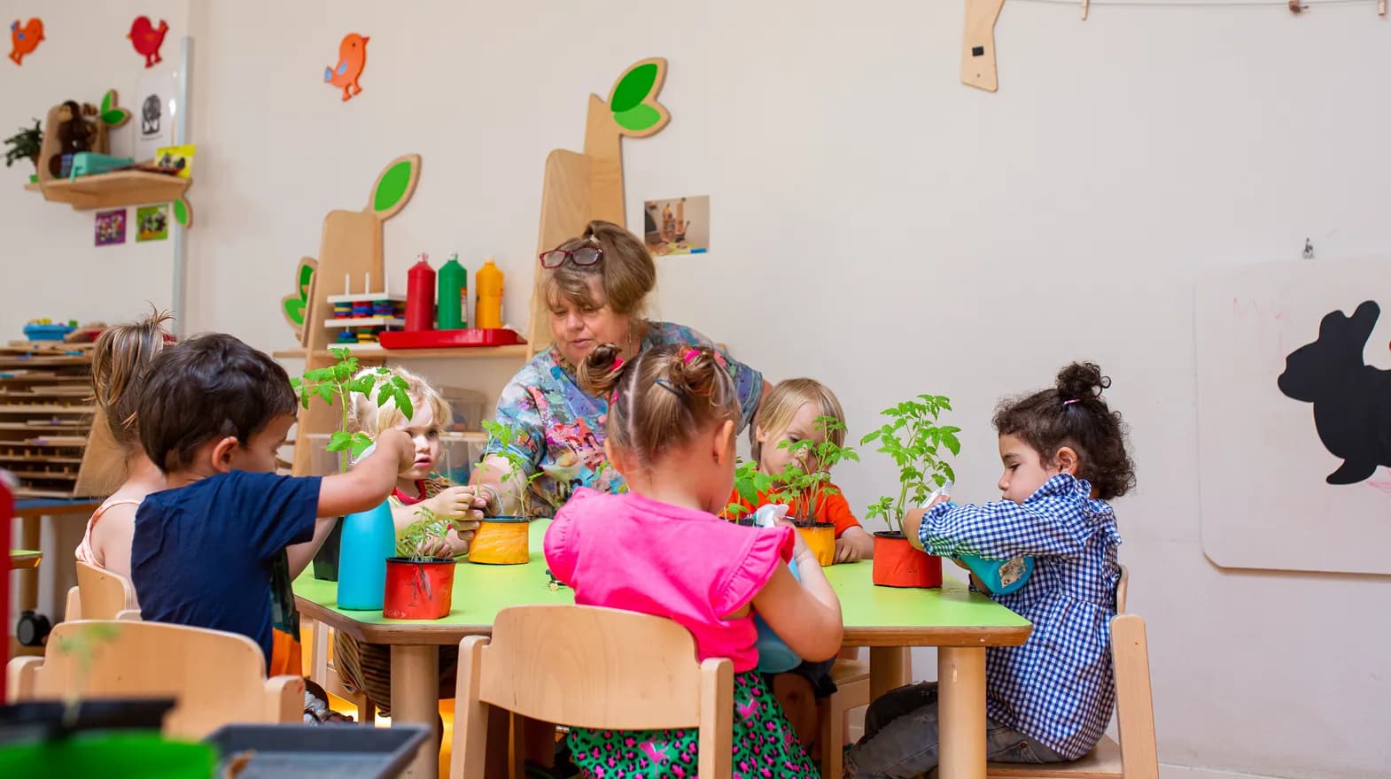 Kinderen zitten aan tafel plantjes te bestuderen bij peuteropvang 't Egeltje, Kind&co ludens