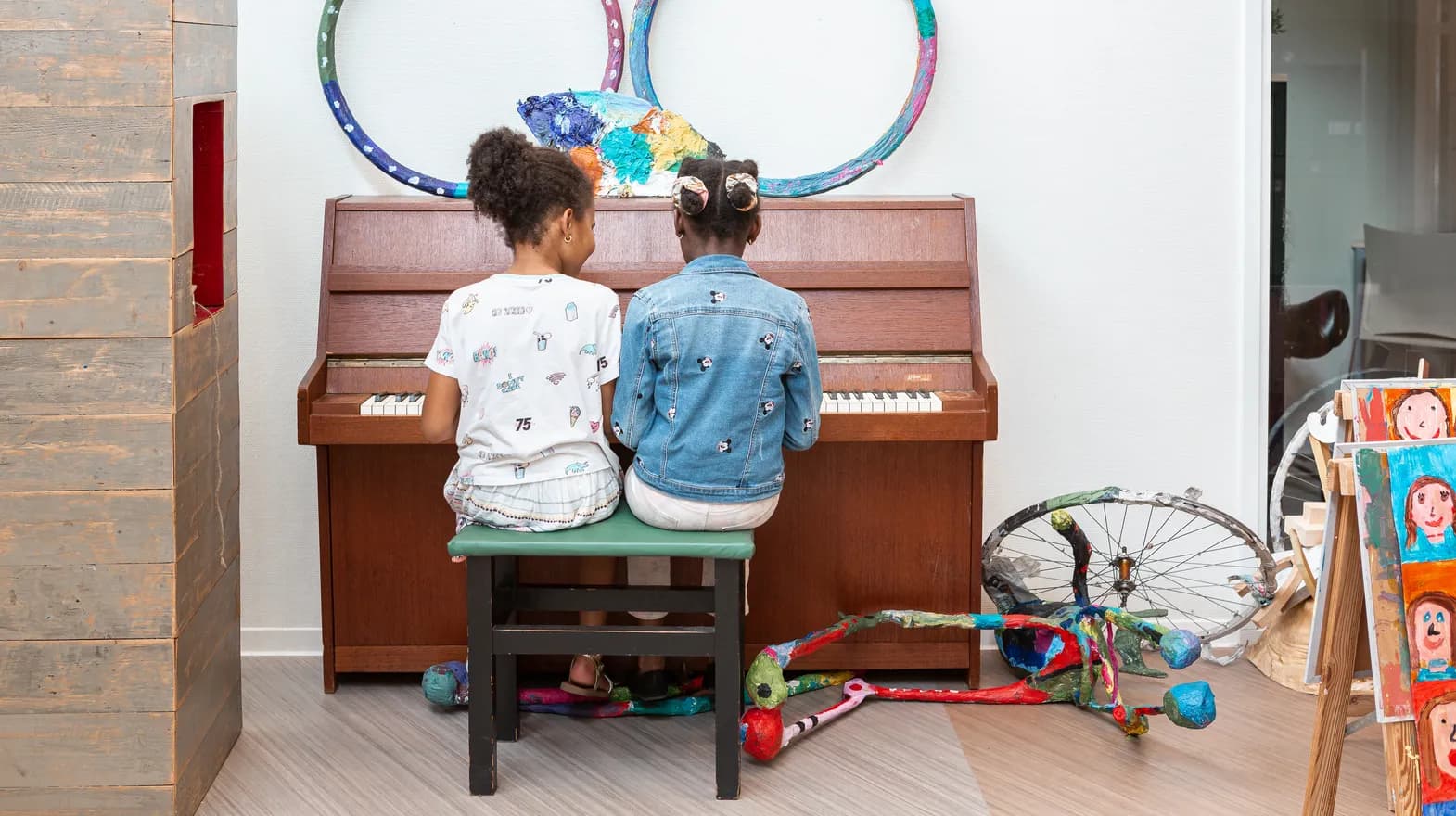 Kinderen spelen samen op de piano bij de BSO van kinderopvang Kind&co ludens