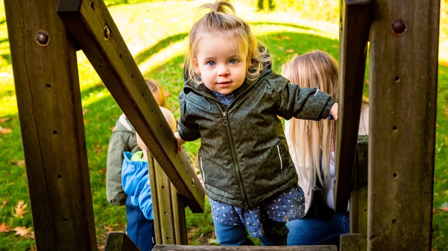 Kind speelt buiten op een speeltoestel bij kinderopvang Kind&co ludens