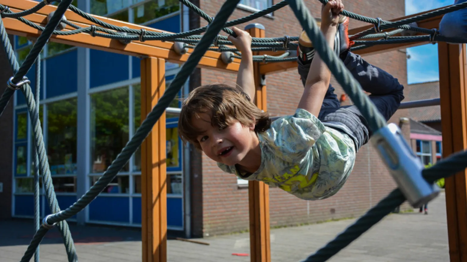 Kind klimt in klimspin bij buitenschoolse opvang spelerij van kinderopvang Kind&co ludens