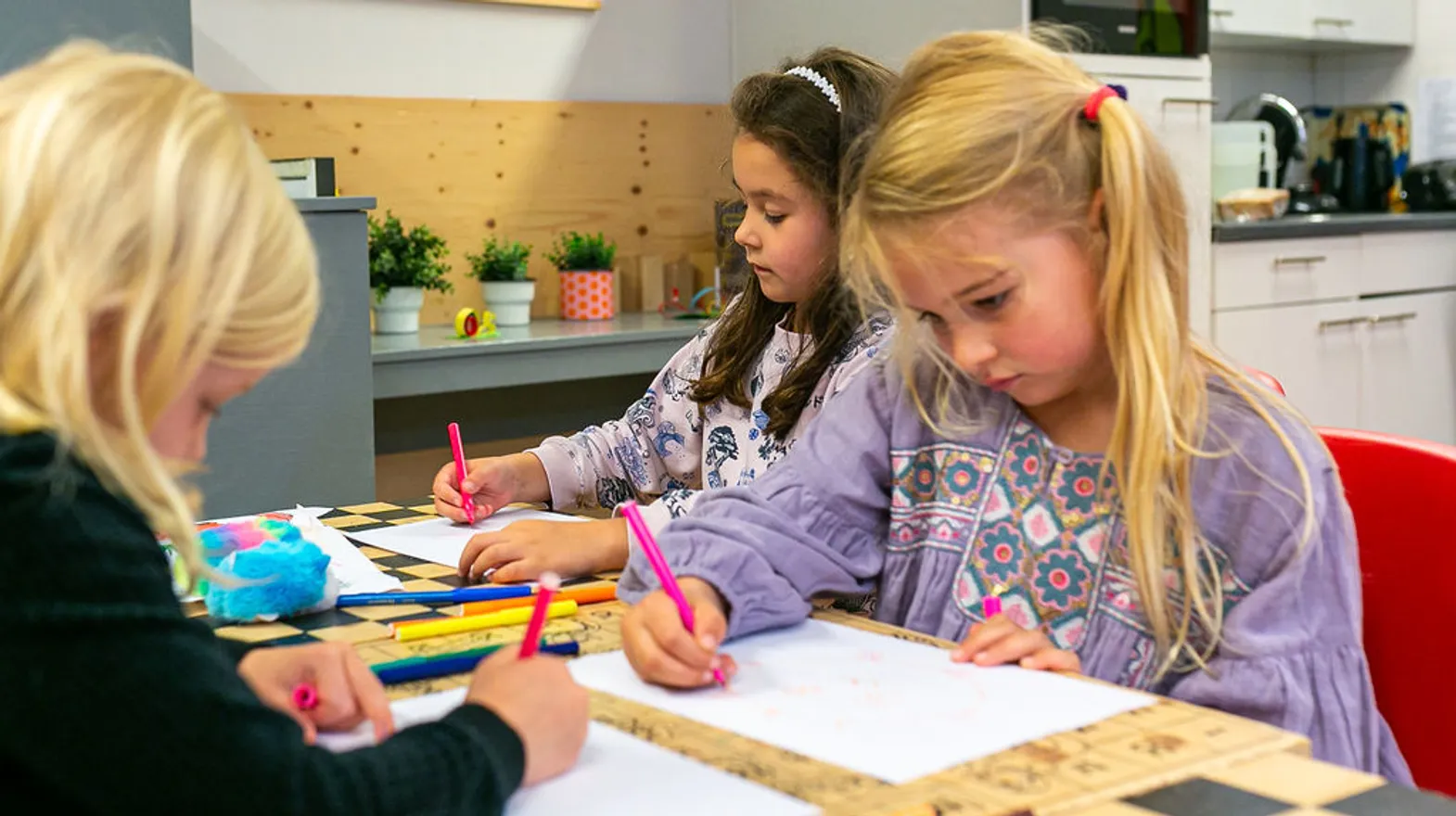 Kinderen aan tafel aan het kleuren bij BSO Orangerie Baarn van Kinderopvang Kind&co ludens