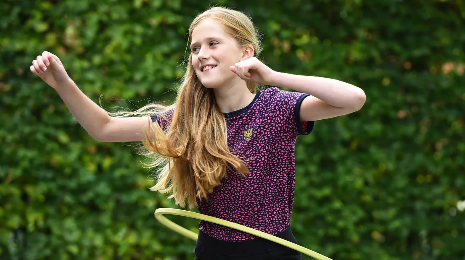 Kind van de BSO hoepelt buiten bij kinderopvang Kind&co ludens