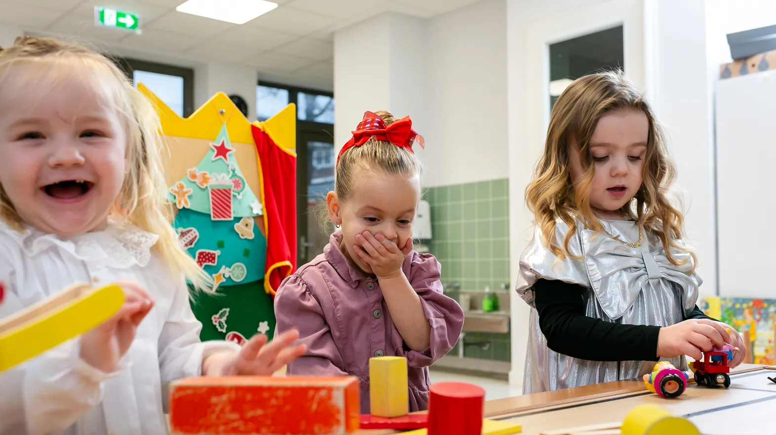 Kinderen van de peutergroep lachen en spelen samen bij kinderopvang Kind&co ludens