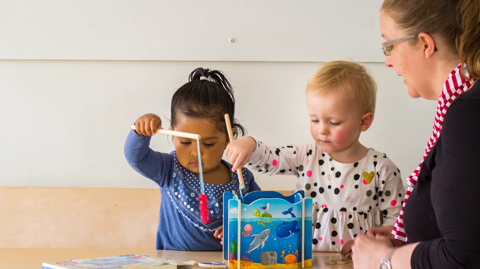 Kinderen spelen samen "Vissen" onder begeleiding van een pedagogisch medewerker bij kinderopvang Kind&co ludens