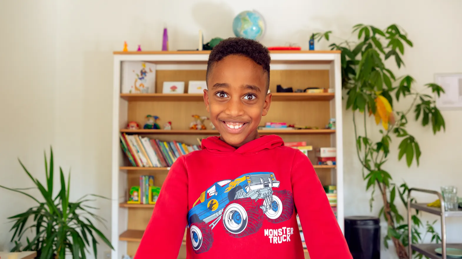 Kind bij de BSO lacht heel blij en straalt bij kinderopvang Kind&co ludens