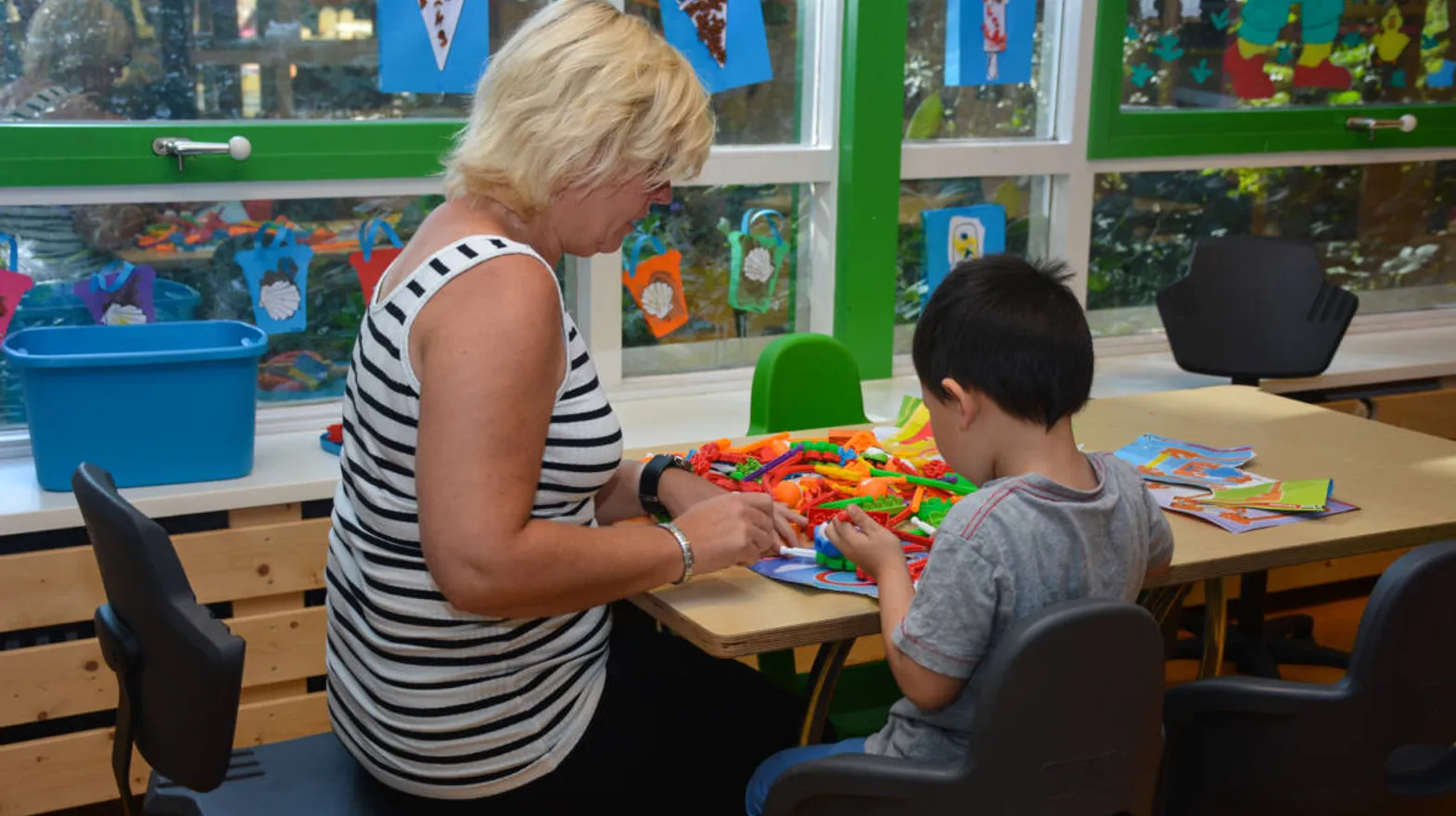 Kind knutselt met pedagogisch medewerker bij Kinderdagverblijf Zeist Kerckebosch van kinderopvang Kind&co ludens