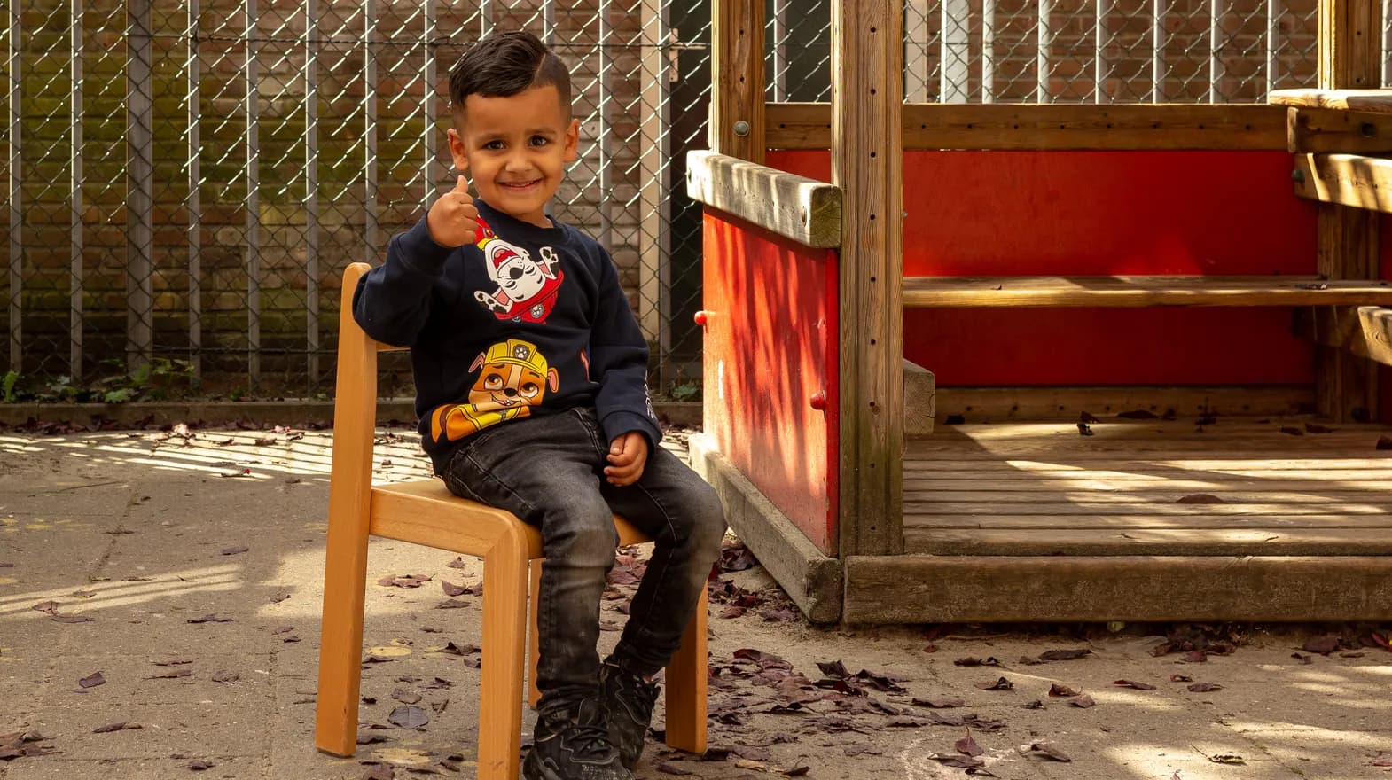 Kind zit buiten op stoeltje bij Peuteropvang Het Margrietje Utrecht van kinderopvang Kind&co ludens