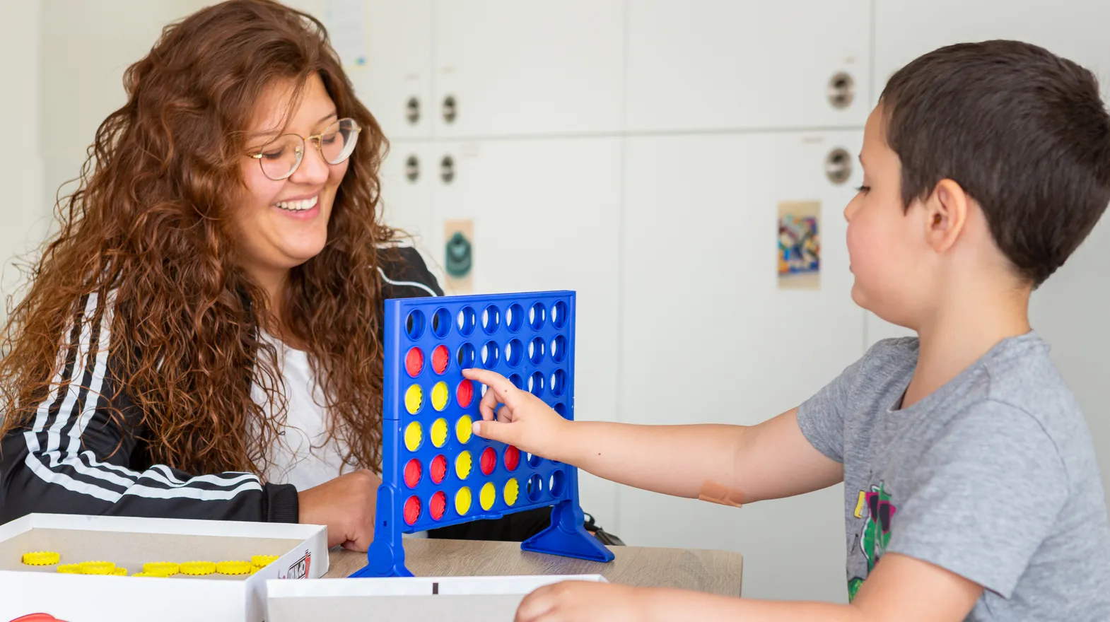 Kind speelt samen met een pedagogisch medewerker een spel bij kinderopvang Kind&co ludens