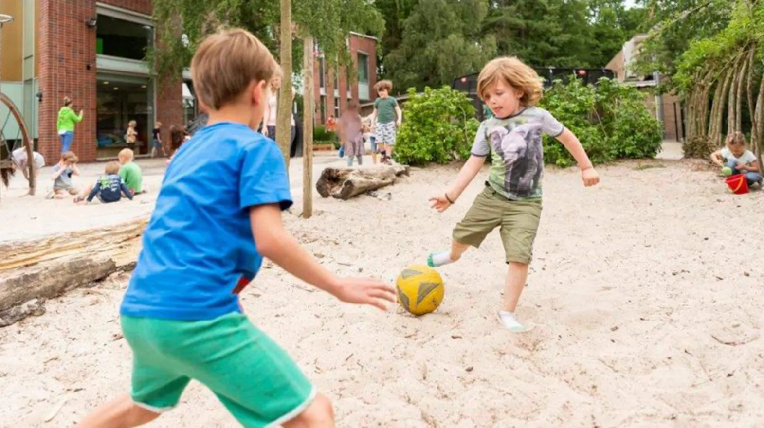 Kinderen spelen met de bal in de buitenruimte bij BSO De Wilde Poema Bilthoven van kinderopvang Kind&co ludens