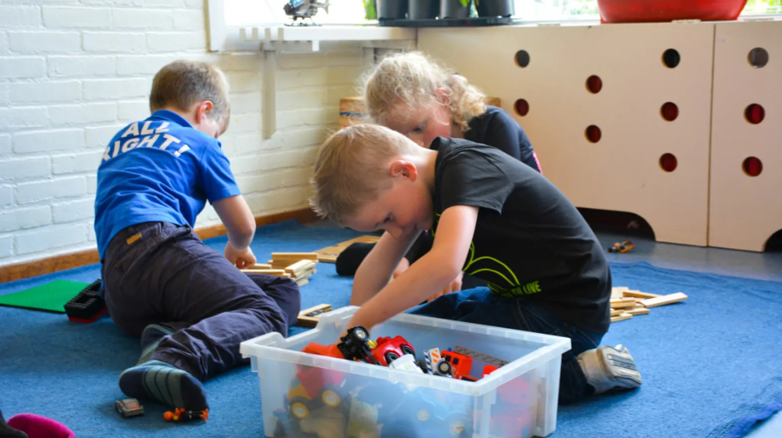 Kinderen bouwen samen met stukjes hout bij buitenschoolse op vang De Kameleon van kinderopvang Kind&co Ludens