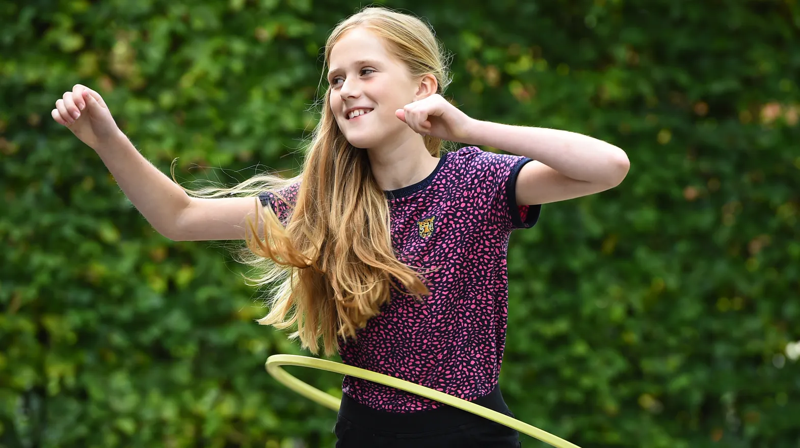 Kind van de BSO hoepelt buiten bij kinderopvang Kind&co ludens