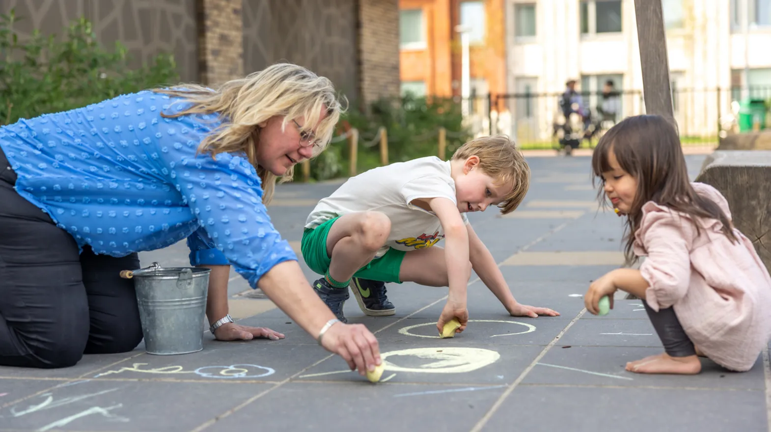 Kinderen stoepkrijten samen bij kinderopvang Kind&co ludens