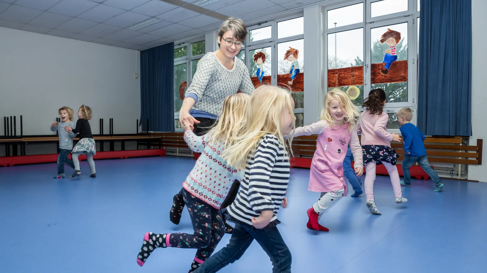 Kinderen van de BSO sporten samen in de gymzaal bij kinderopvang Kind&co ludens