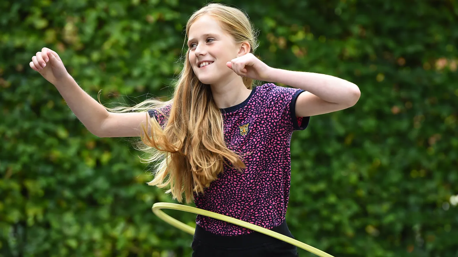 Kind van de BSO hoepelt buiten bij kinderopvang Kind&co ludens