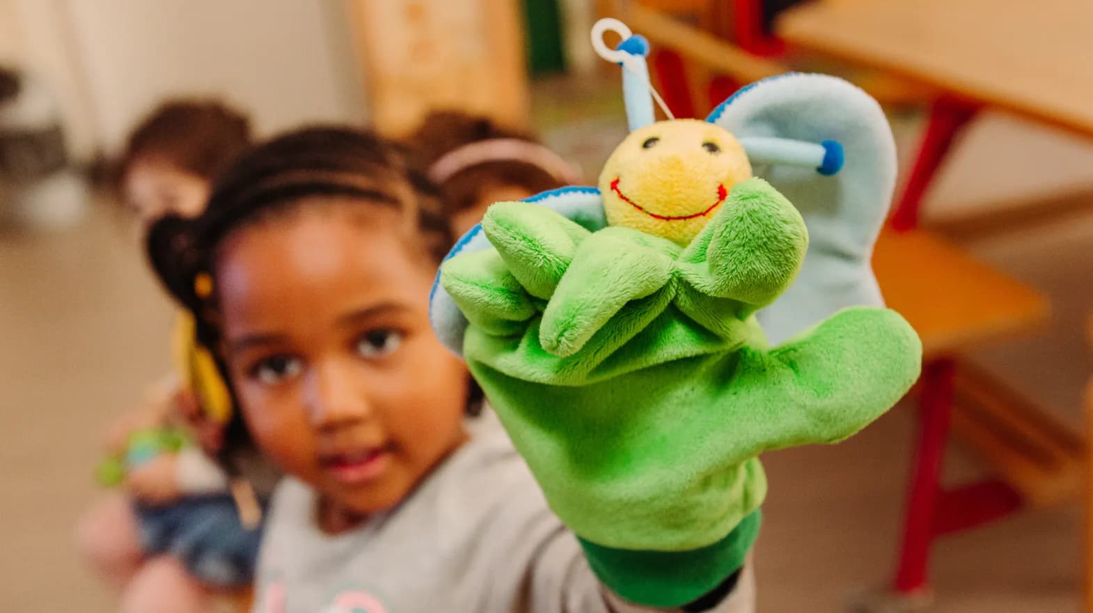 Kind van de peutergroep speelt met handpop bij kinderopvang Kind&co ludens