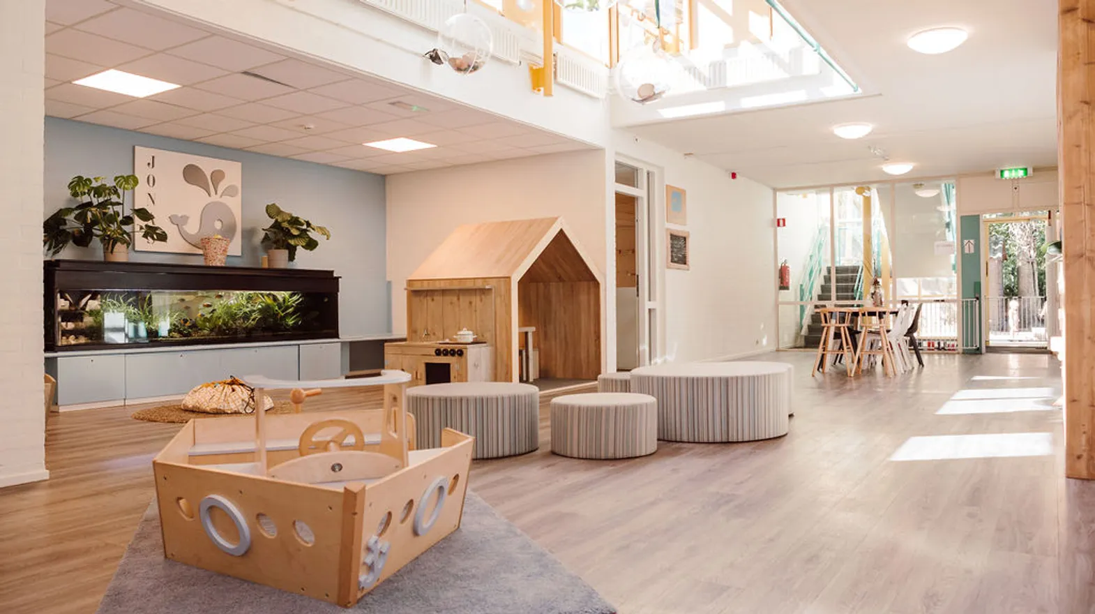 De groepsruimte met aquarium, houten speelboot en speelhuis bij kinderdagverblijf Jonas, kinderopvang Kind&co ludens