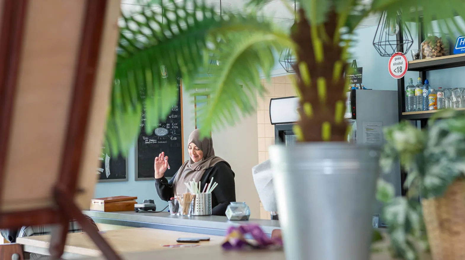 Pedagogisch medewerker staat lachend in de groepsruimte van buitenschoolse opvang Synergo, Kind&co ludens