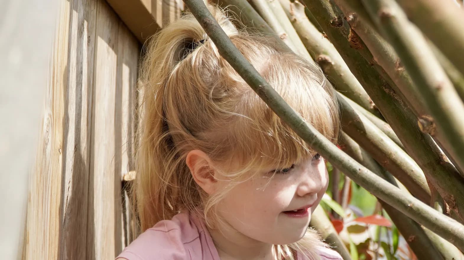 Kind speelt buiten in Wilgentakken huisje bij gastouder van kinderopvang Kind&co ludens
