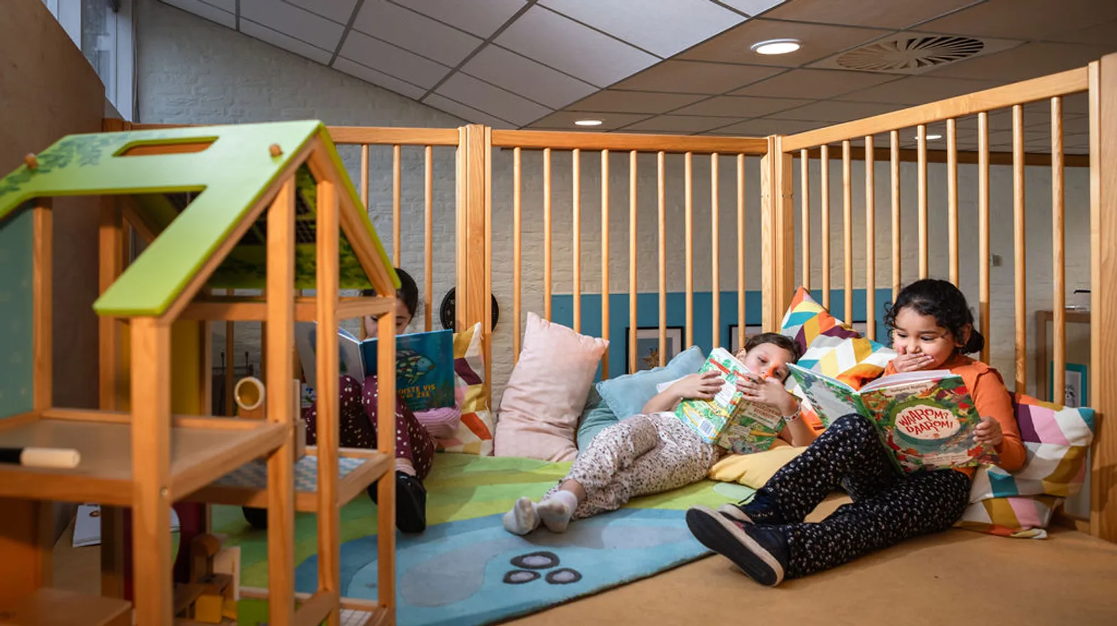 Kinderen lezen een boek in de boekenhoek van buitenschoolse opvang Villa Kofschip, kinderopvang Kind&co Ludens