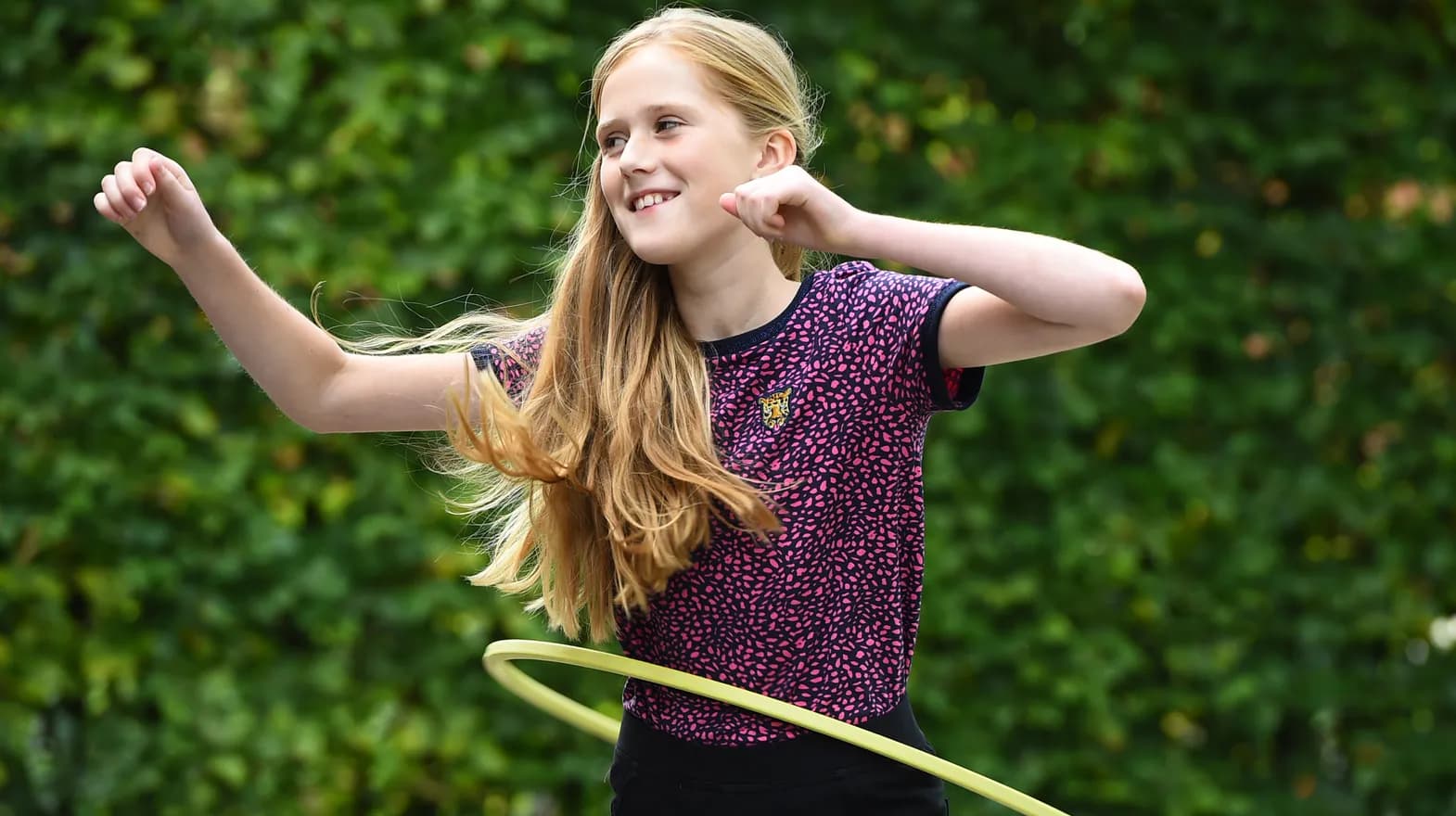 Kind van de BSO hoepelt buiten bij kinderopvang Kind&co ludens