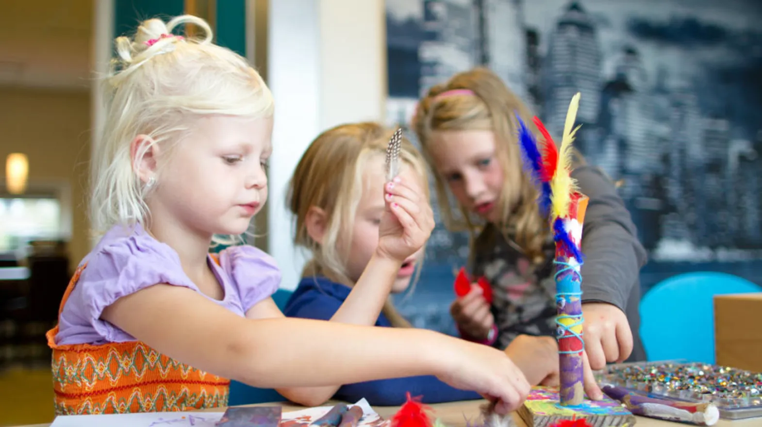 Kinderen knutselen met veertjes bij buitenschoolse opvang Touwladder, kinderopvang Kind&co Ludens