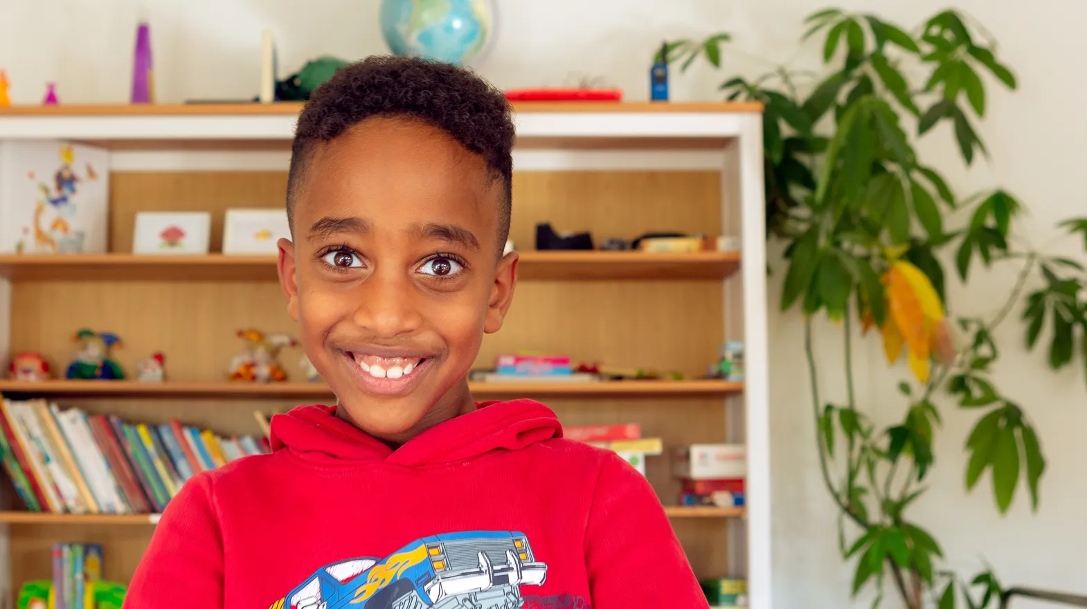 Kind bij de BSO lacht heel blij en straalt bij kinderopvang Kind&co ludens