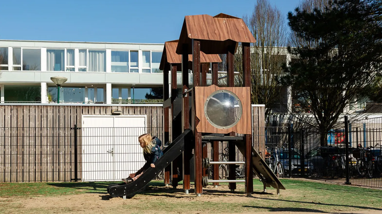 Kind glijd van het speeltoestel in de buitenruimte bij Peuteropvang De Meern van kinderopvang Kind&co ludens