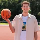 Collega met bal op een sportveld op de BSO