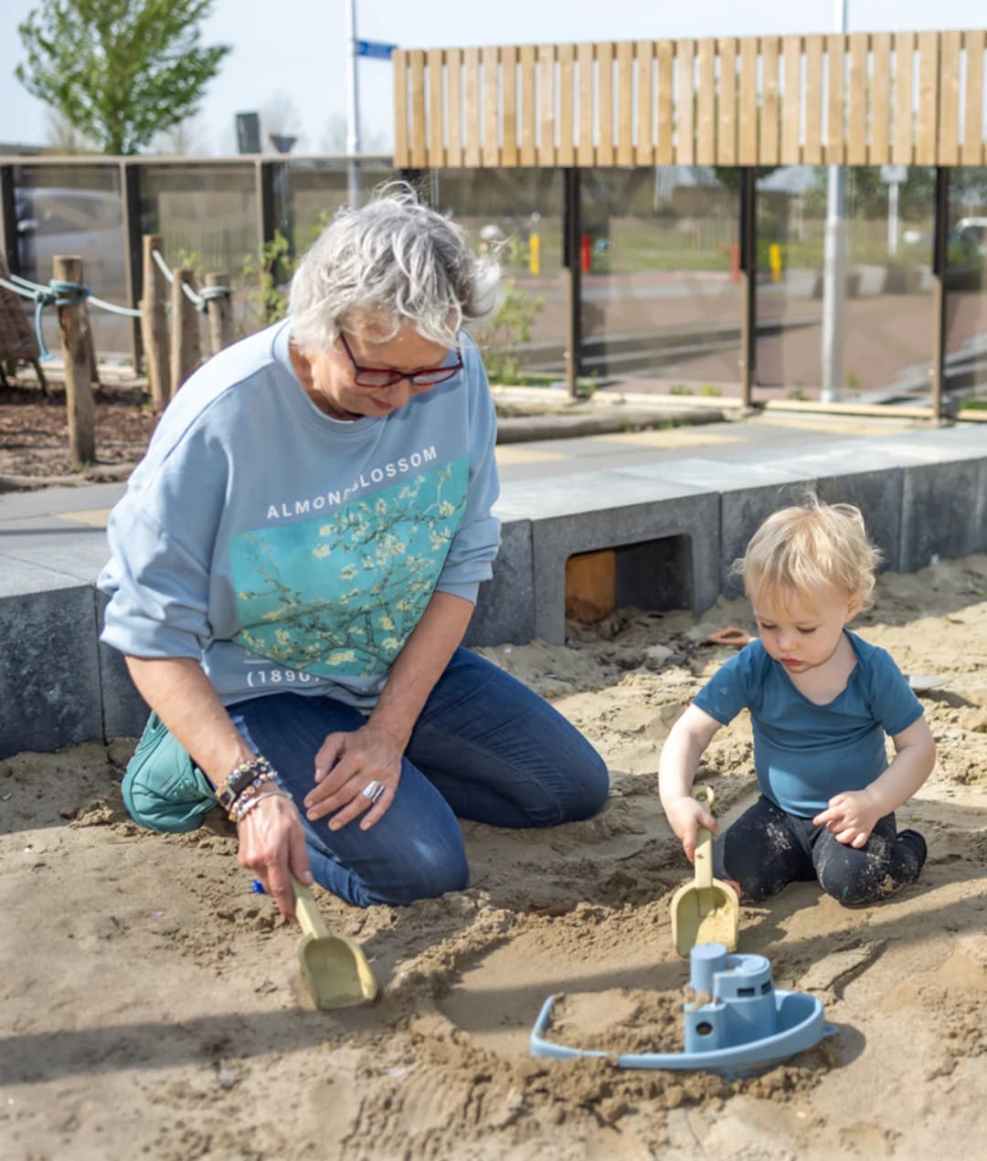 Kinderen spelen in zandbak met pedagogisch medewerker bij Kind&co ludens