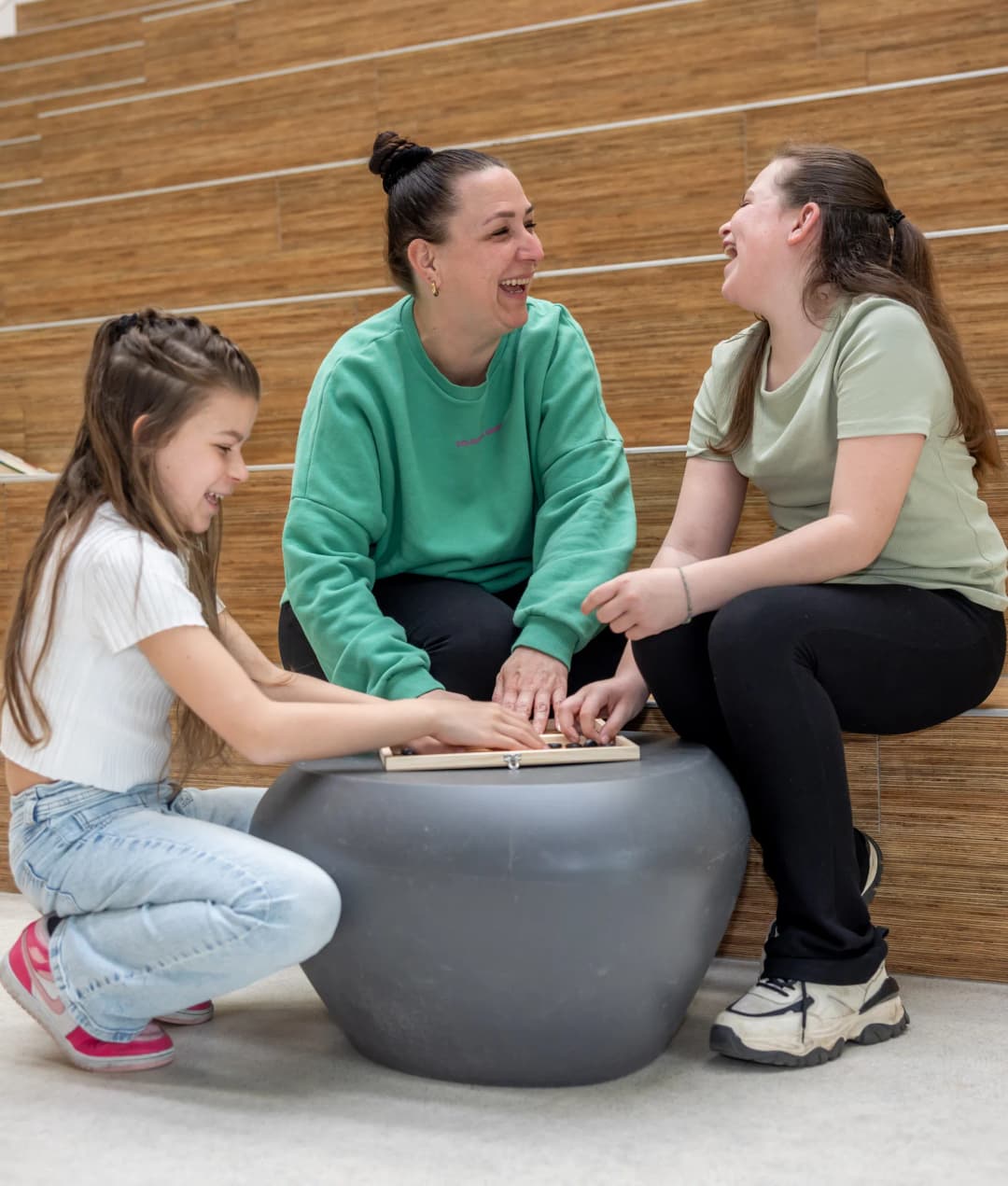 Kinderen spelen een spel met pedagogisch medewerkers en hebben lol bij kinderopvang Kind&co ludens