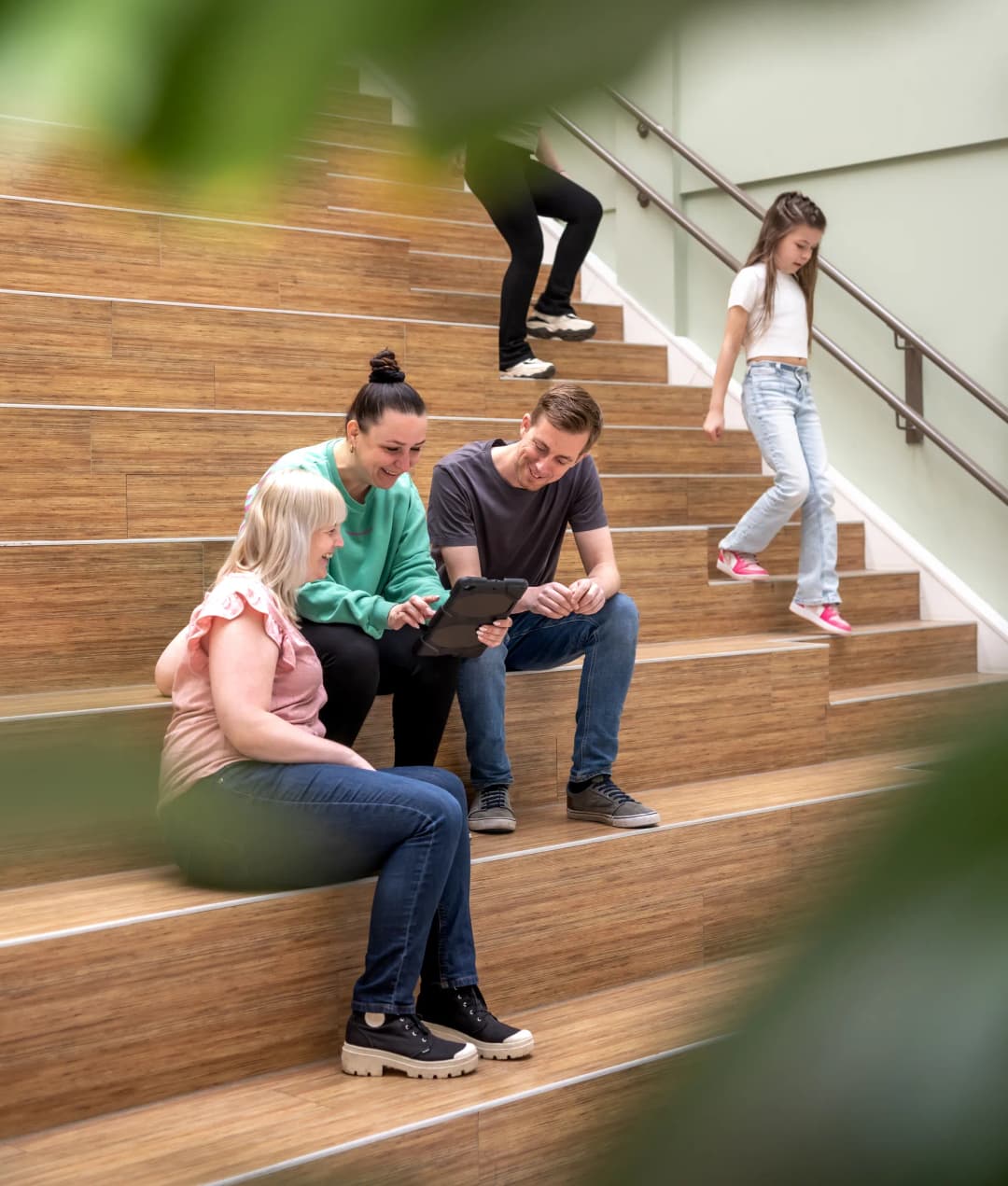 collega's met iPad op de trap bij kinderopvang Kind&co ludens