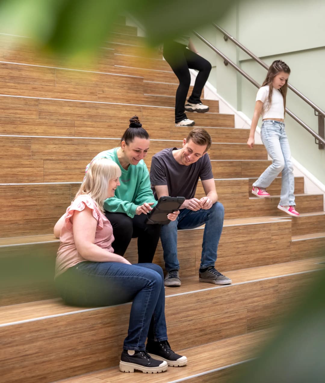 collega's met iPad op de trap bij kinderopvang Kind&co ludens
