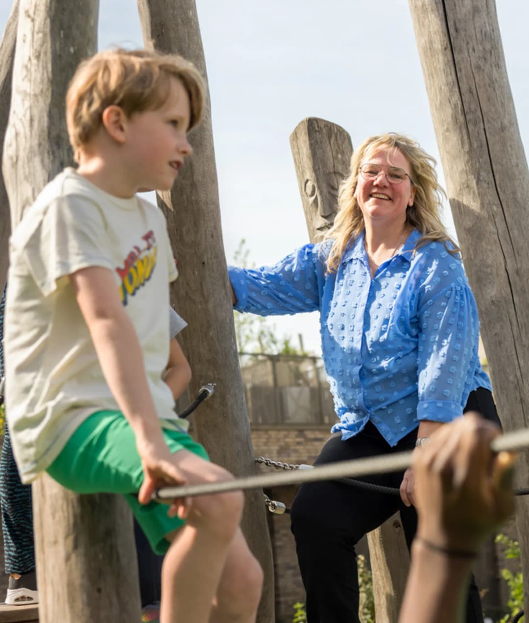 Kind speelt buiten met pedagogisch medewerker bij kinderopvang Kind&co ludens