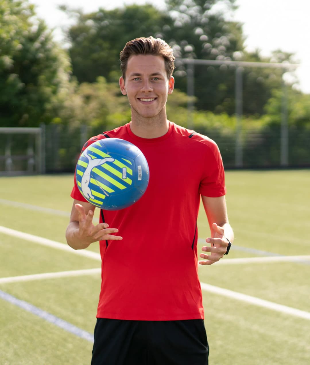 Collega met bal in zijn hand op een sportveld op de BSO