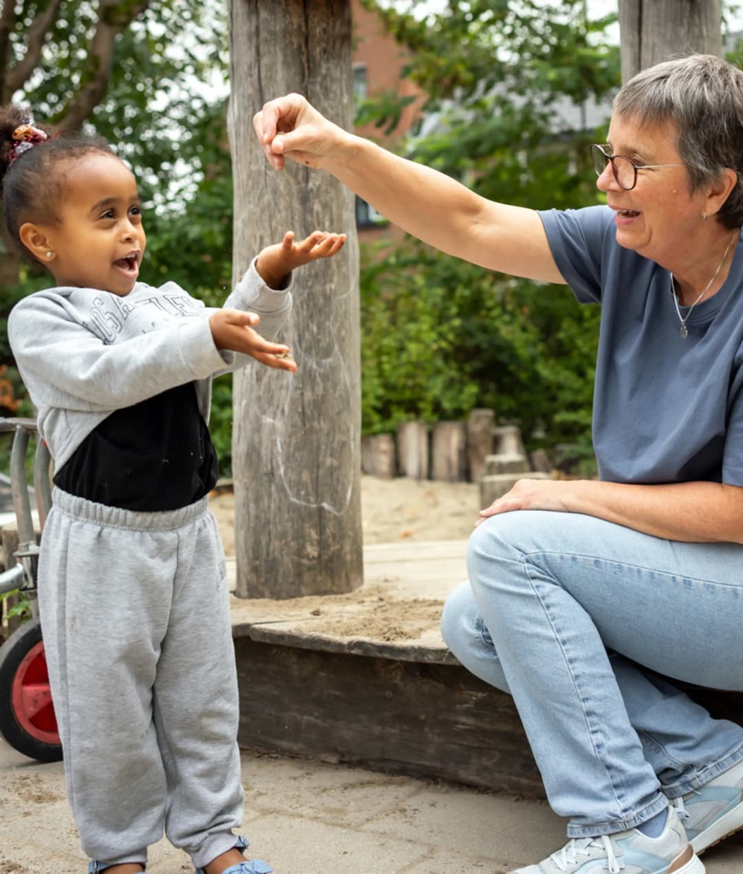 Kind speelt buiten met pedagogisch medewerker bij kinderopvang Kind&co ludens