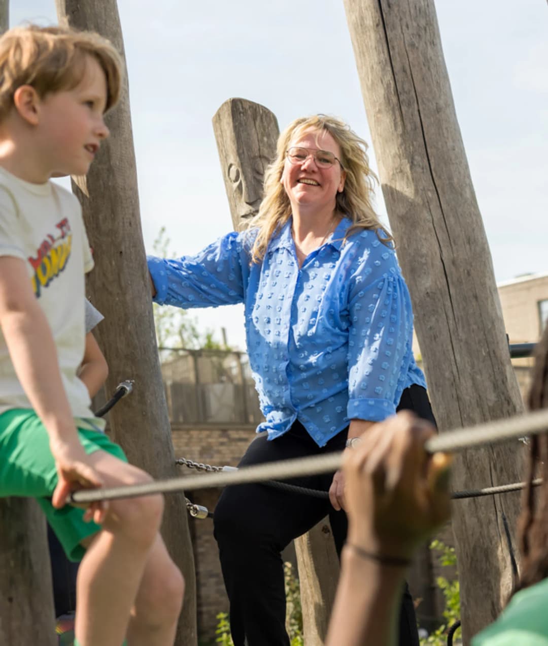 Kind speelt buiten met pedagogisch medewerker bij kinderopvang Kind&co ludens