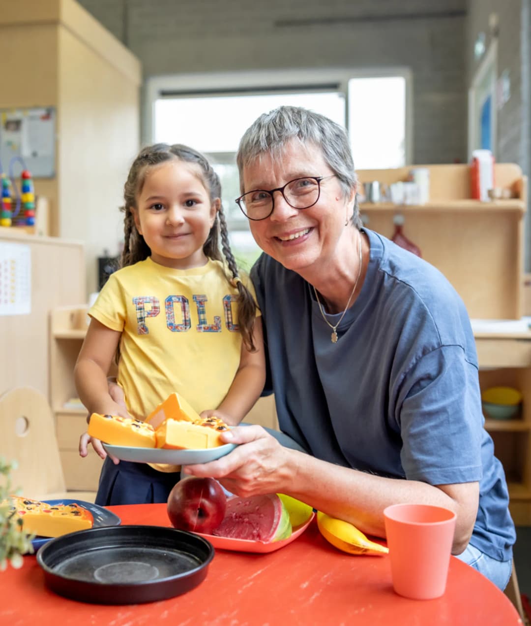 Kind speelt met pedagogisch medewerker in kinderkeuken bij kinderopvang Kind&co ludens