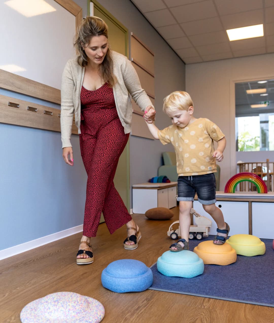 Kind speelt samen met pedagogisch medewerker met stapelstenen bij kinderopvang Kind&co ludens