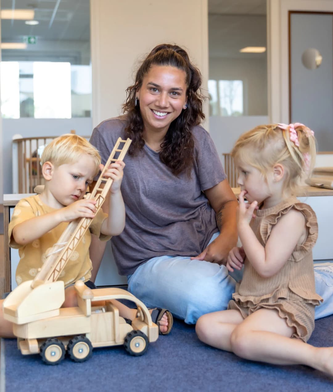 Kinderen spelen samen met pedagogisch medewerker bij kinderopvang Kind&co ludens