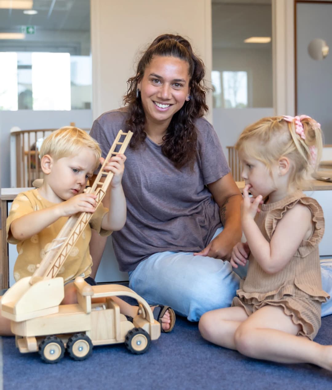 Kinderen spelen samen met pedagogisch medewerker bij kinderopvang Kind&co ludens