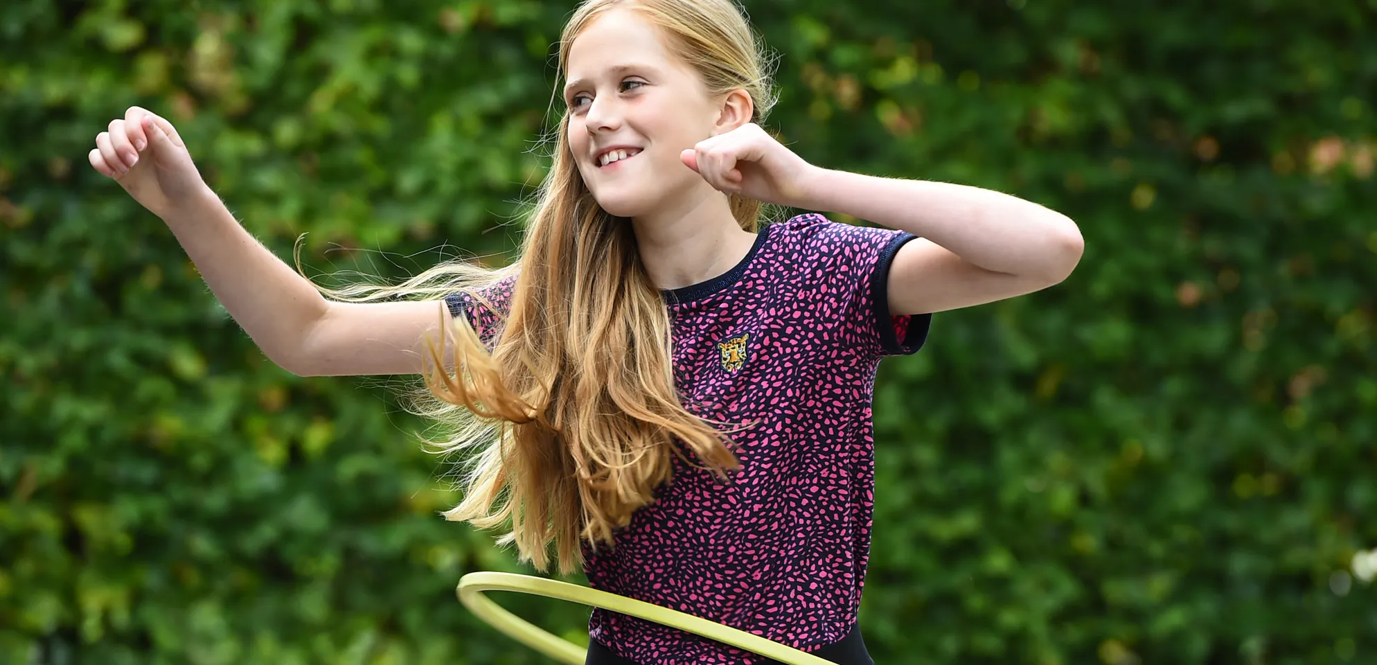 Kind van de BSO hoepelt buiten bij kinderopvang Kind&co ludens