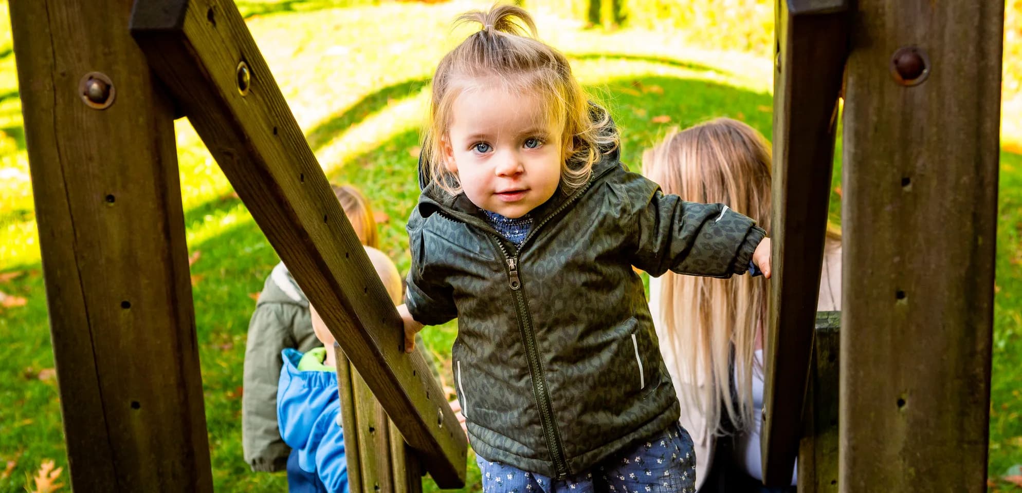 Kind speelt buiten op een speeltoestel bij kinderopvang Kind&co ludens
